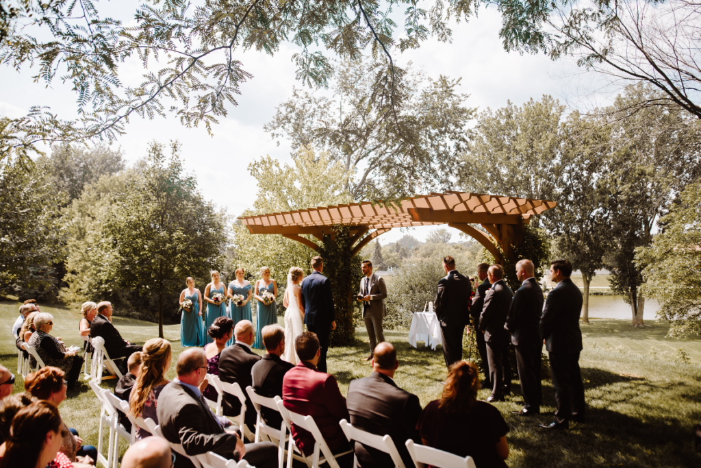 Bride and groom share vows under pergola at wedding venue
