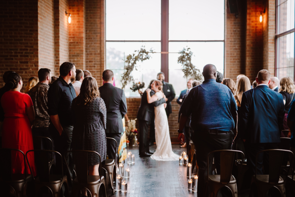 Bride walks down the aisle as guests look on